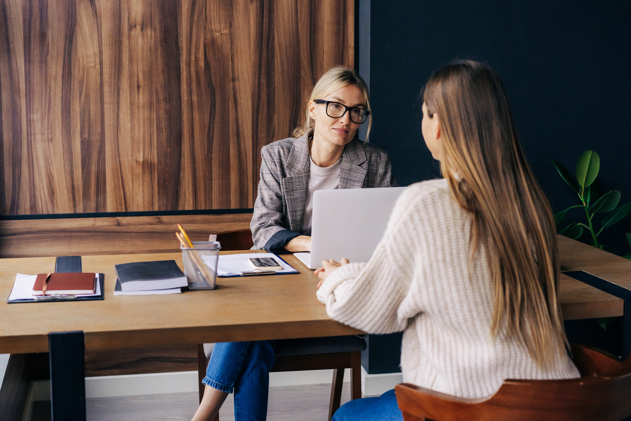 Two business women work and discuss in a modern office.